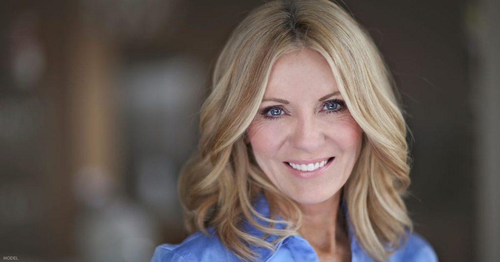 A woman with short hair and blue eyes smiles after receiving a BOTOX® treatment in Dallas, TX