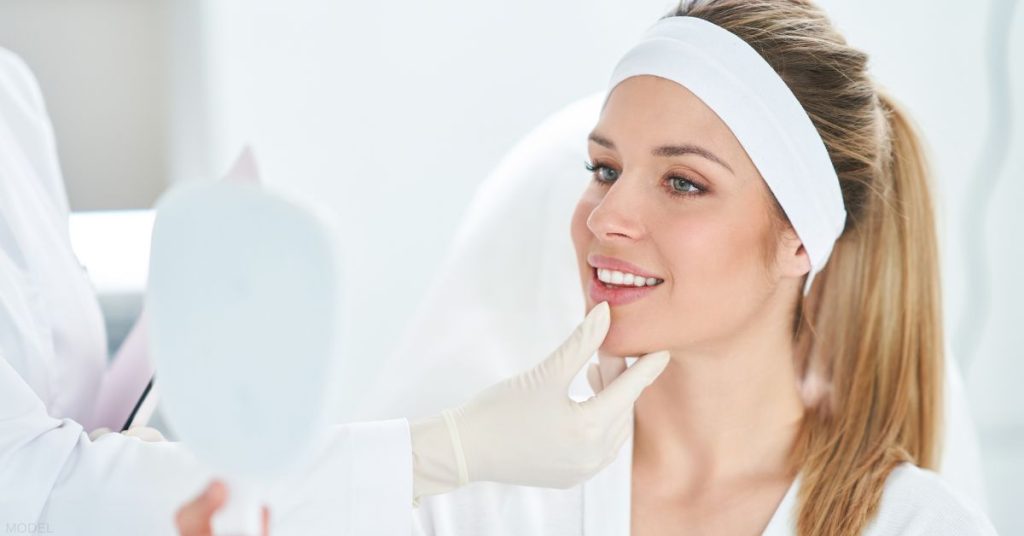 Women in white headband smiling in the mirror (MIRROR)